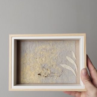tableau d'un petit renard endormi à travers le feuillage.