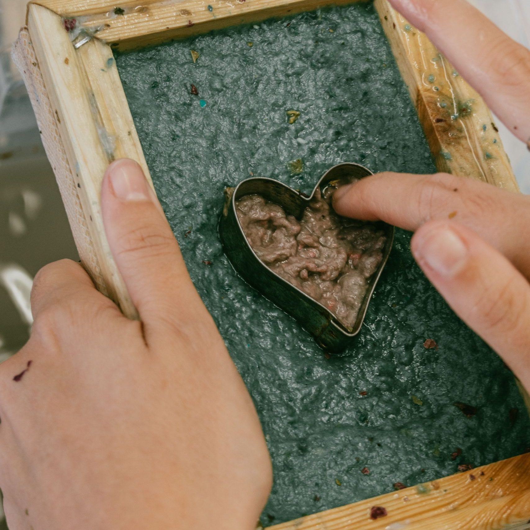 R&eacute;alisation d'une feuille de papier recycl&eacute; avec un motif de coeur lors d'un atelier cr&eacute;atif artistique &agrave; Clermont-Ferrand, pour faire un petit bijou po&eacute;tique et unique.