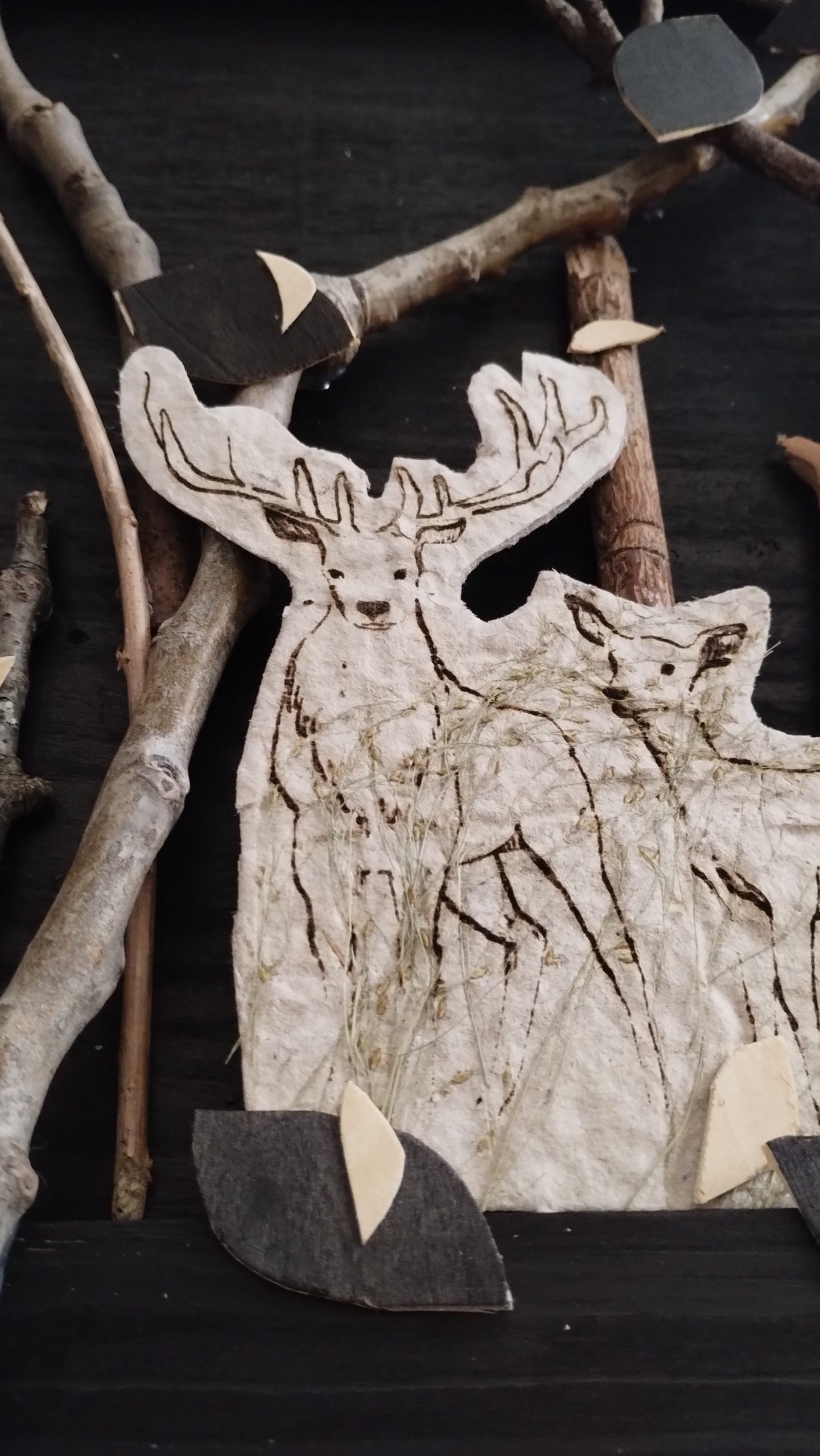 gros plan sur un tableau en bois encore de chine et papier recyclé avec illustration d'une famille de biches