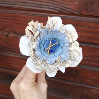 fleur en papier recyclé et feuille de livre avec une lave émaillée en son centre.