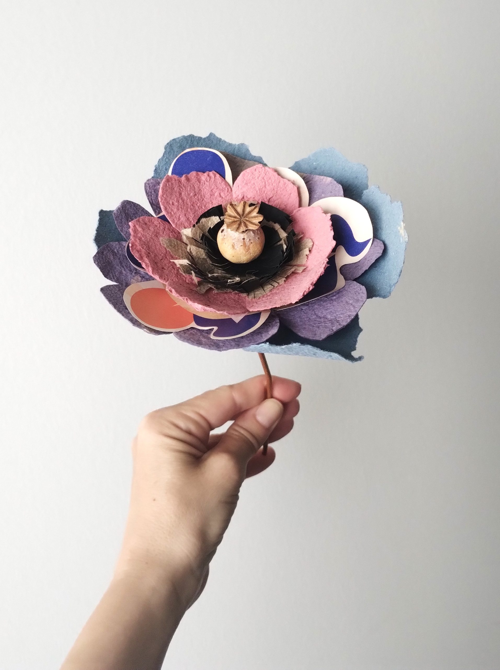 Fleur en papier recyclé et surcyclé avec une affiche