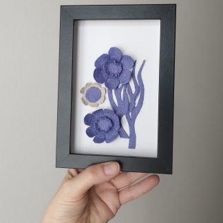Petit tableau simple élégant et épuré avec des fleurs bleues sur fond blanc. Encadrement noir