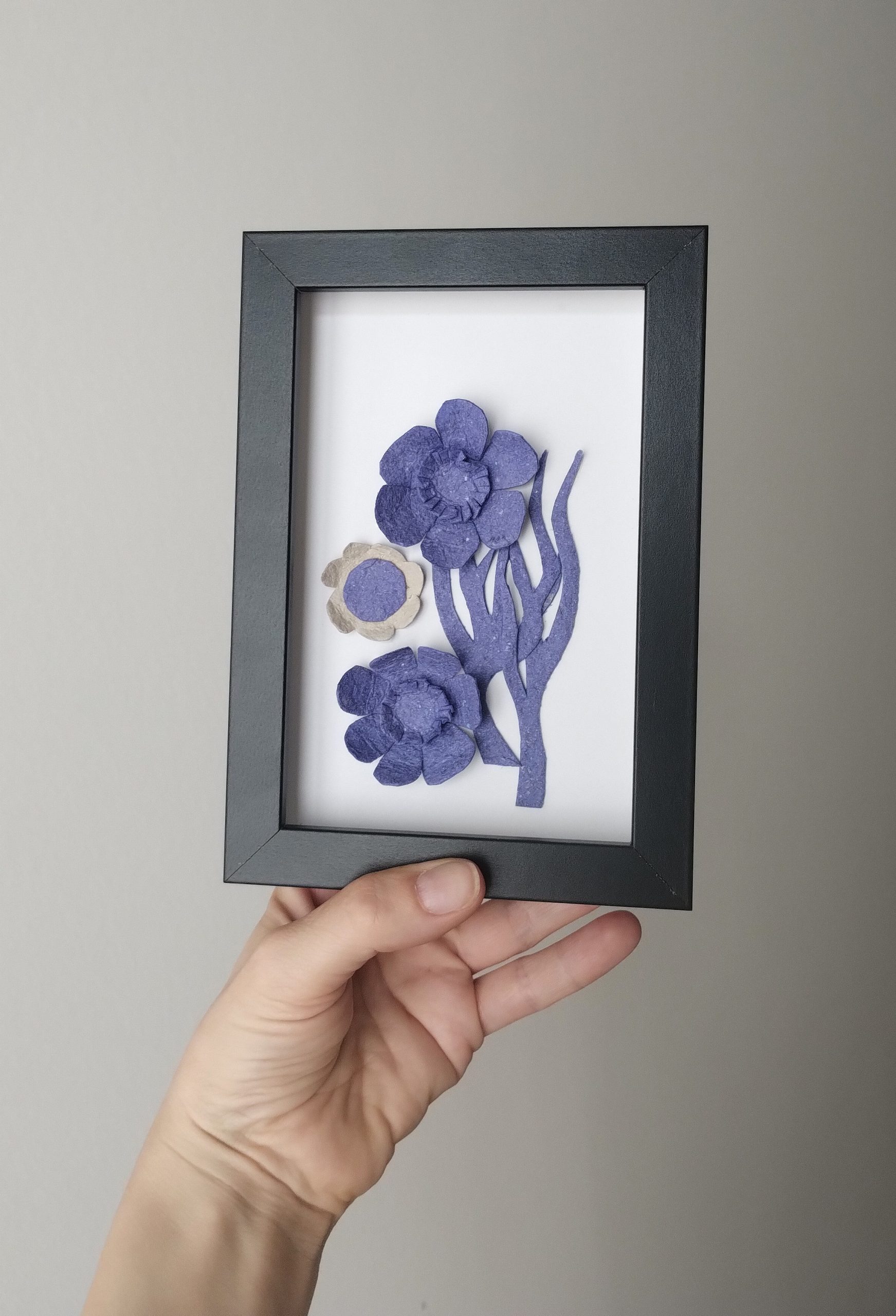 Petit tableau simple élégant et épuré avec des fleurs bleues sur fond blanc. Encadrement noir